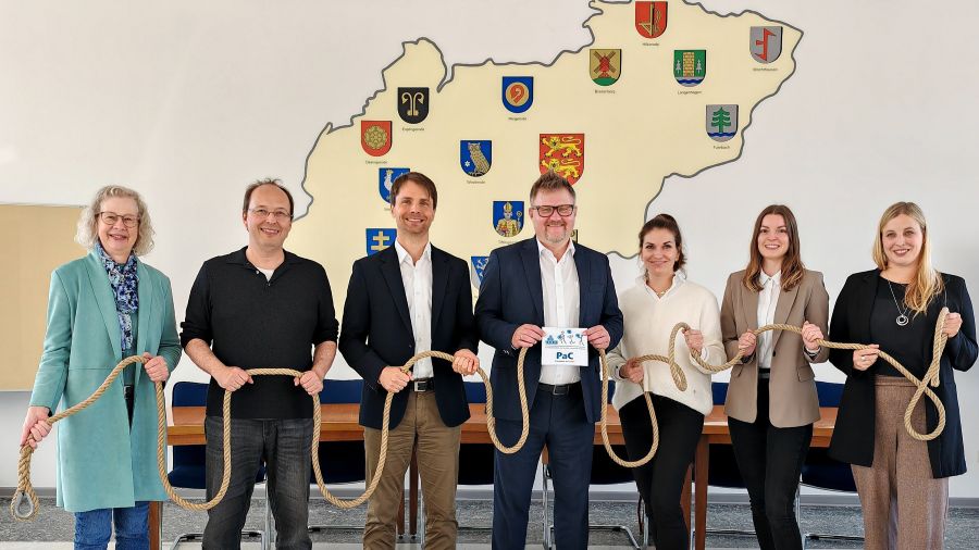 Das Foto zeigt die Beteiligten, alle halten am gleichen dicken Seil fest, der Bürgermeister in der Mitte zeigt außerdem das PaC-Logo.