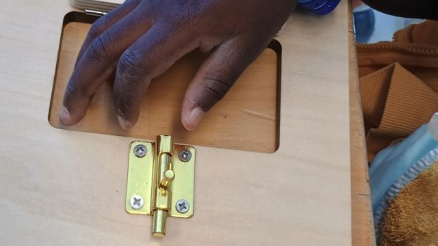 Das Foto zeigt eine Hand, die ein Türschloss geöffnet hat.