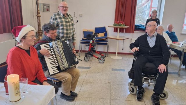 Das Foto zeigt den Schifferklavierspieler mit weiteren Teilnehmenden der Feier.